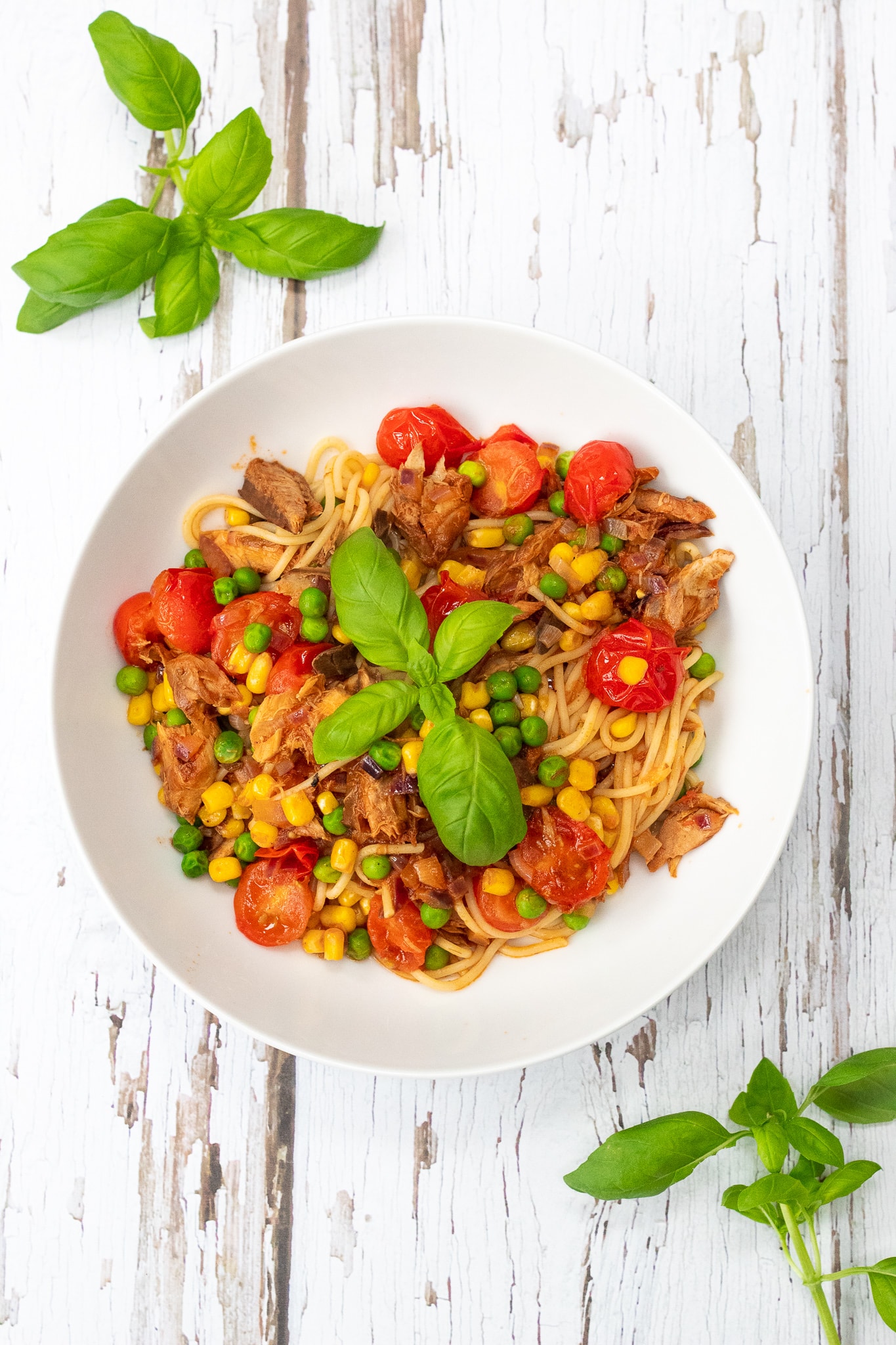 Bowl of spaghetti with tinned mackerel, cherry tomatoes, peas and sweetcorn