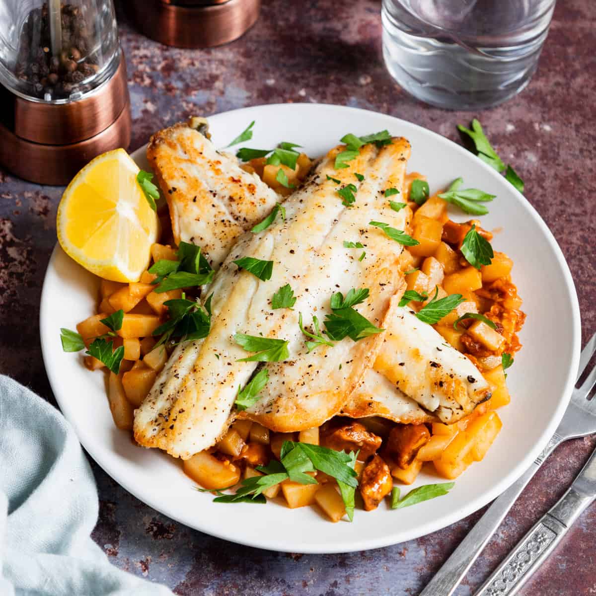 plate of chorizo potato risotto topped with sea bass