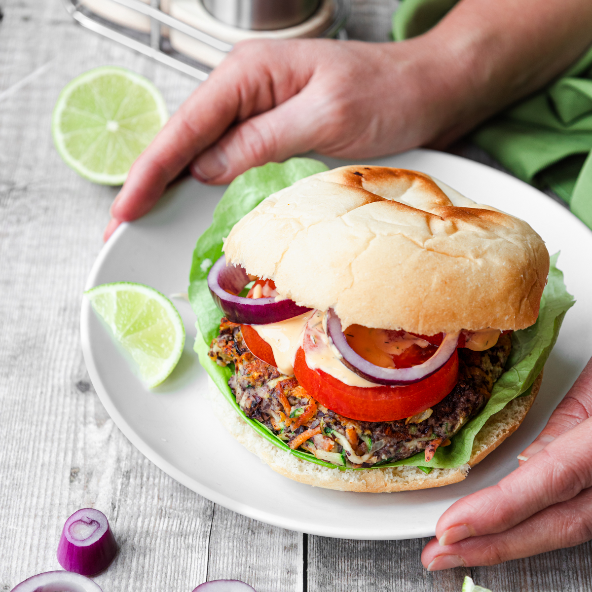 Black bean burger in a bun with hands