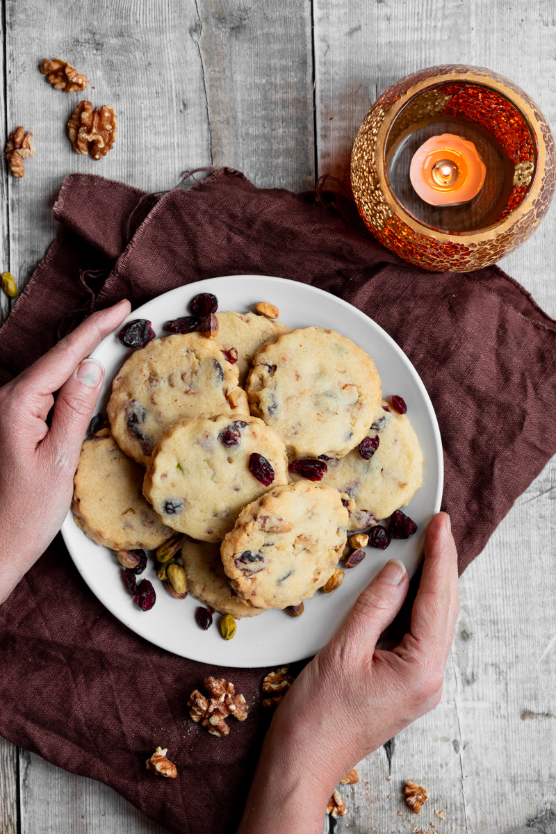 flatlay of nutty shortbread style biscuits with cranberries