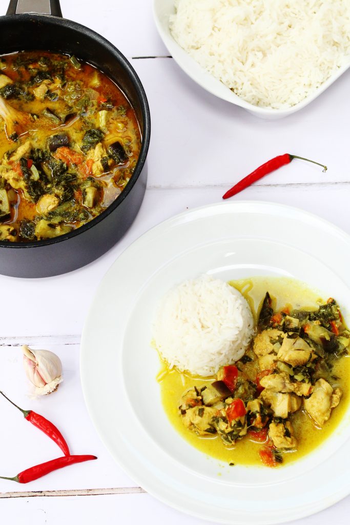 chicken and callaloo curry on a plate with rice