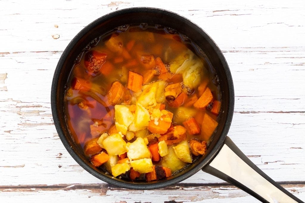 Roasated vegetables and stock in a saucepan