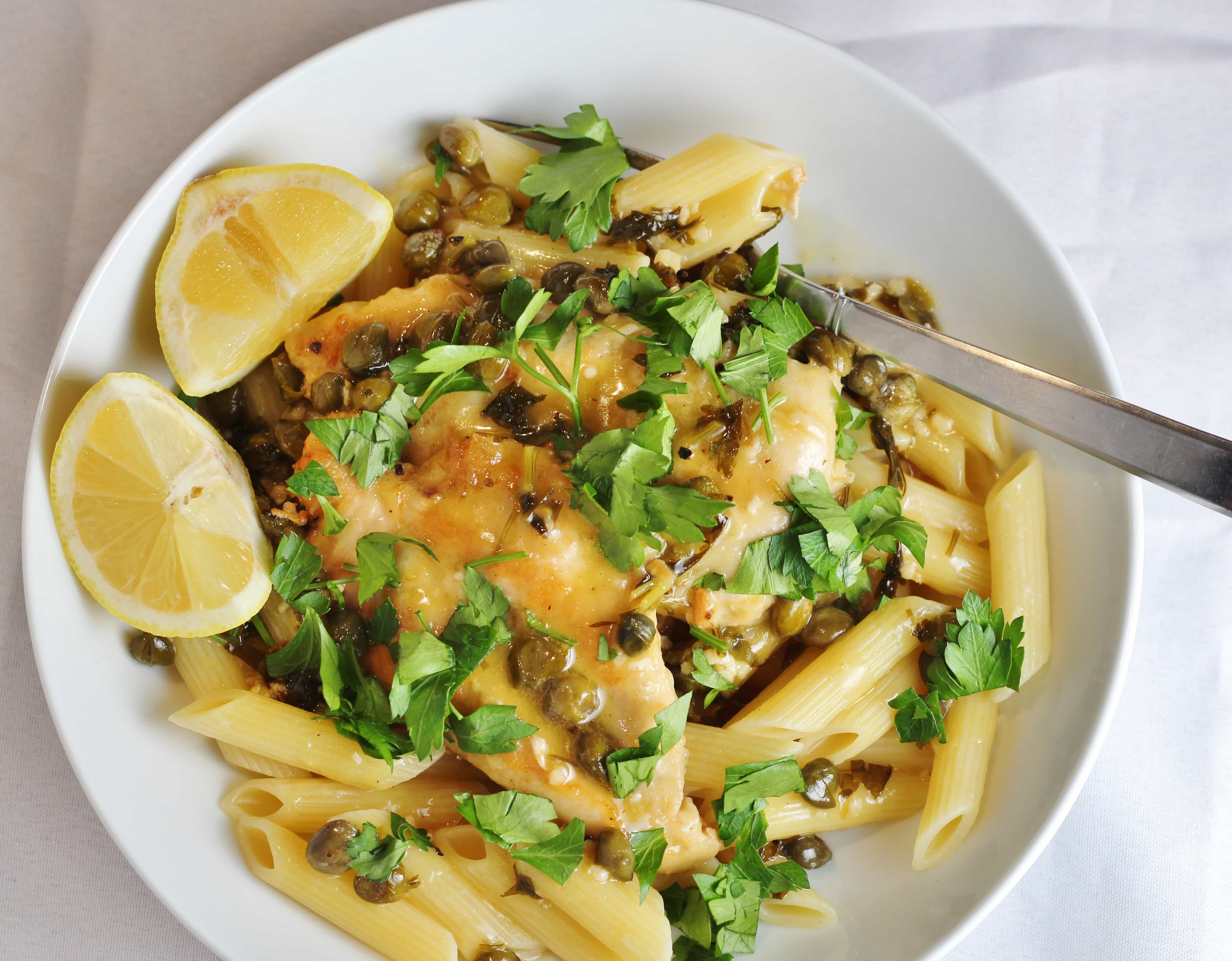 Chicken piccata with lemon wedges