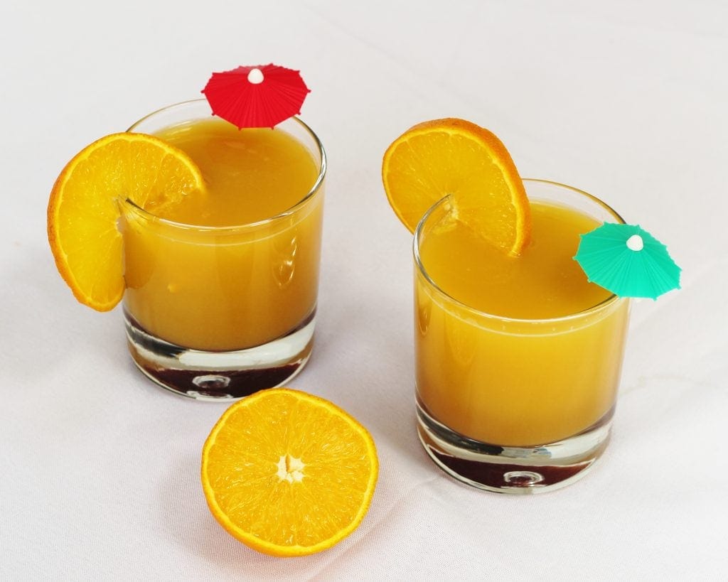 Two glasses of orange and pomegranate molasses mocktail