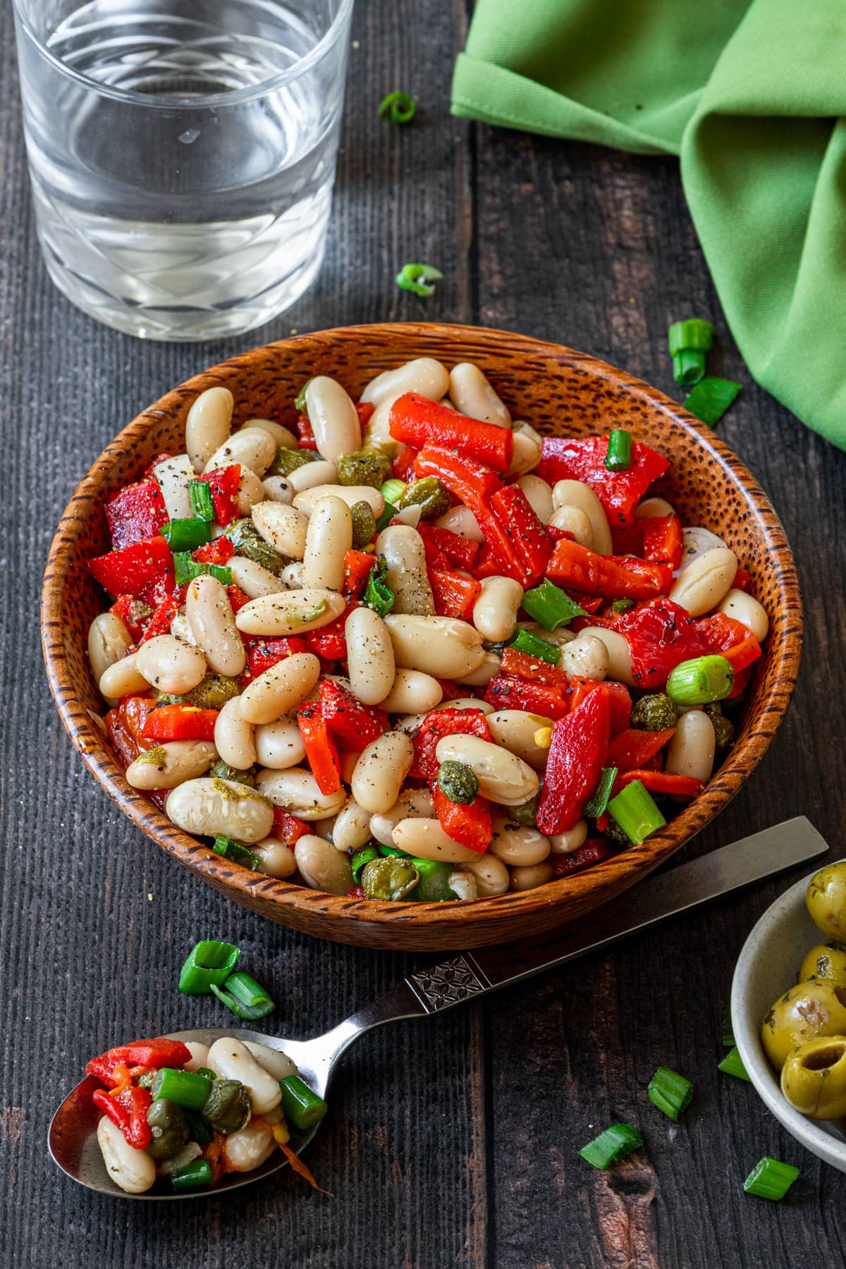 spanish bean salad in a bowl plus water and spoon