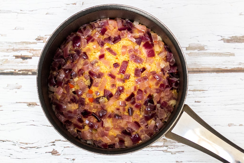couscous in a pan with red onions