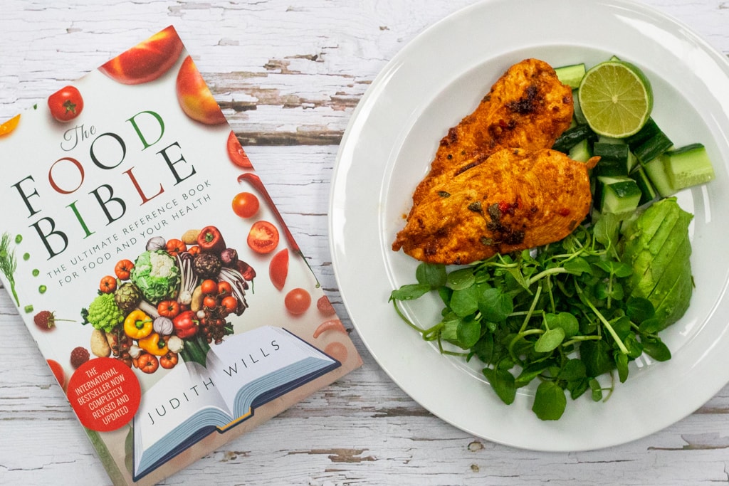 Plate of chipotle lime chicken and copy of The Food Bible