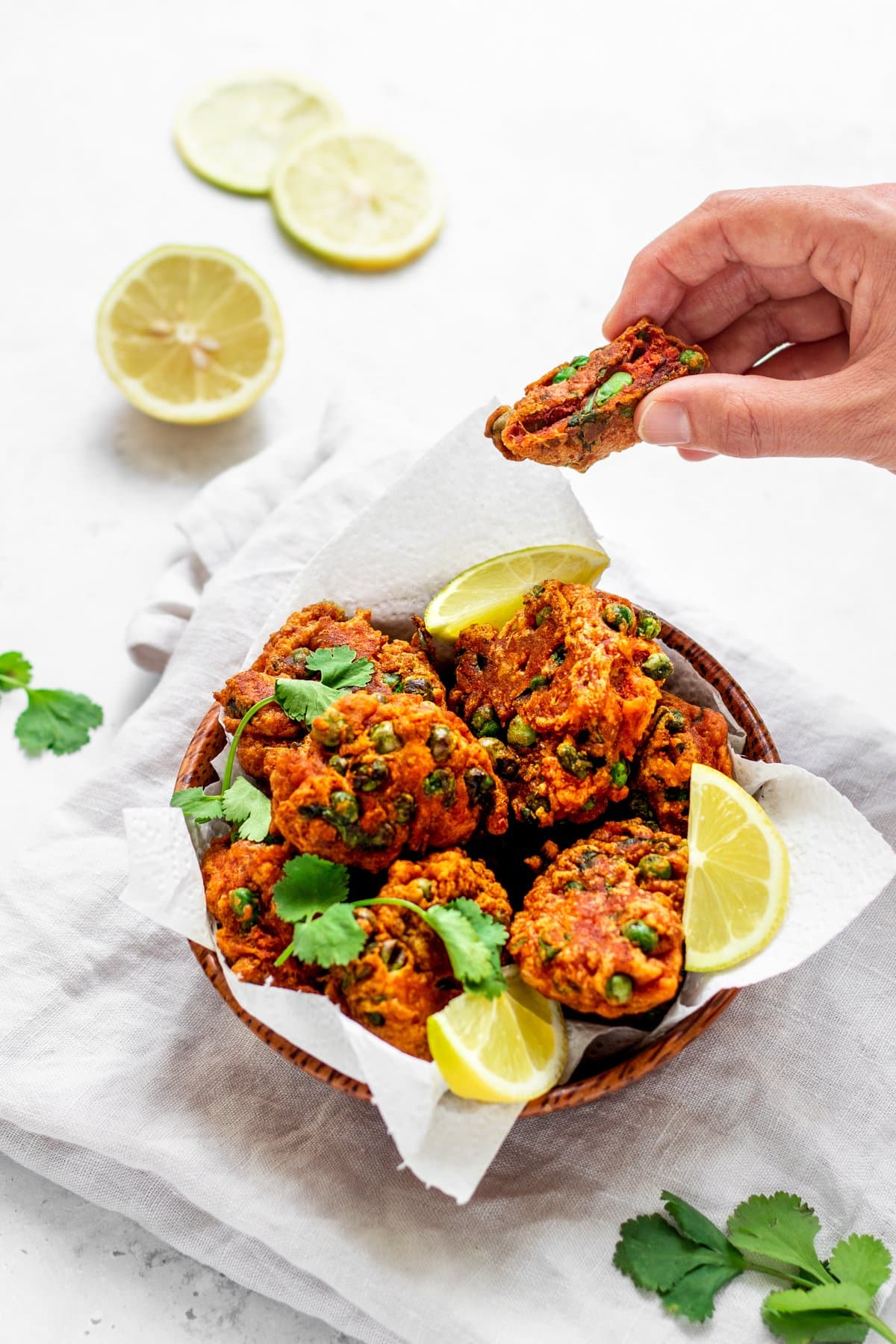 Hand taking a pea pakora from the bowl