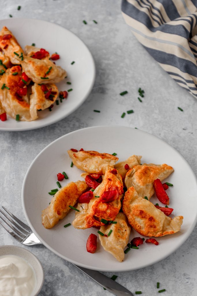 two plates of Polish cheese and potato pierogi