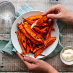 Hand holding sweet potato wedge