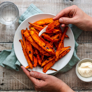 Hand holding sweet potato wedge