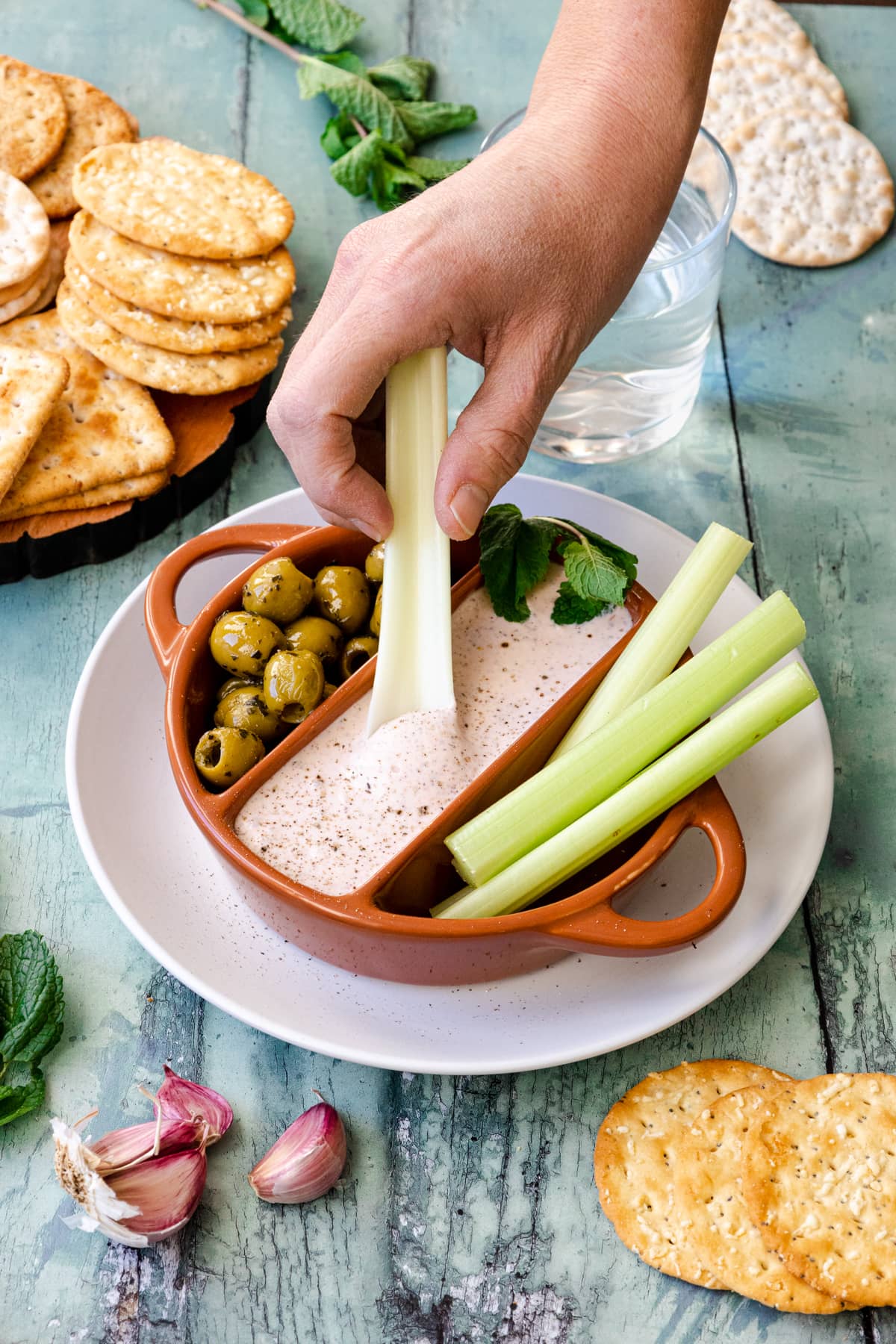 hand dipping celery in feta dip