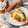Hands holding an air fried jacket potato