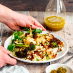 Salad with a glass bottle of jalapeno lime vinaigrette