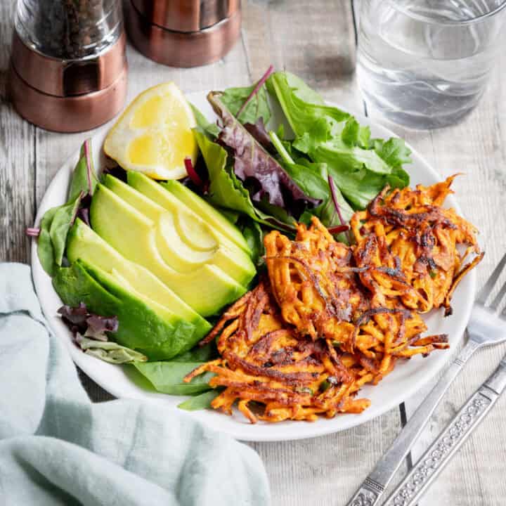 Spicy sweet potato fritters with salad and avocado