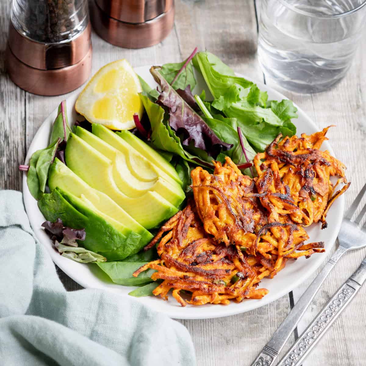 Spicy sweet potato fritters with salad and avocado