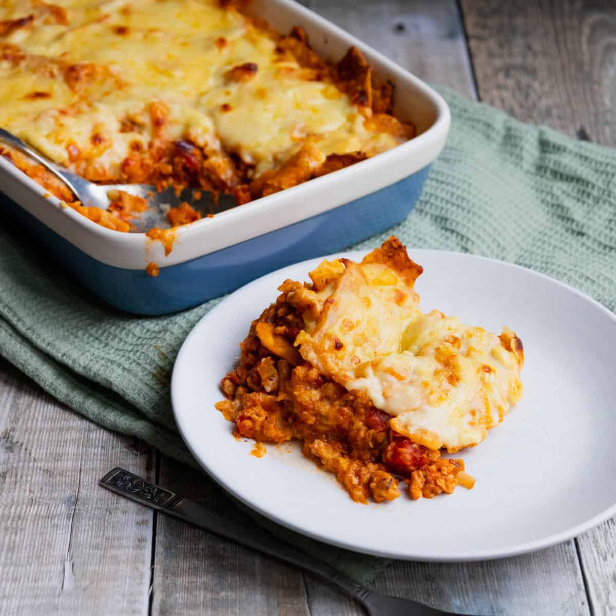 Plate of doritos lasagne with dish of lasagne in the background